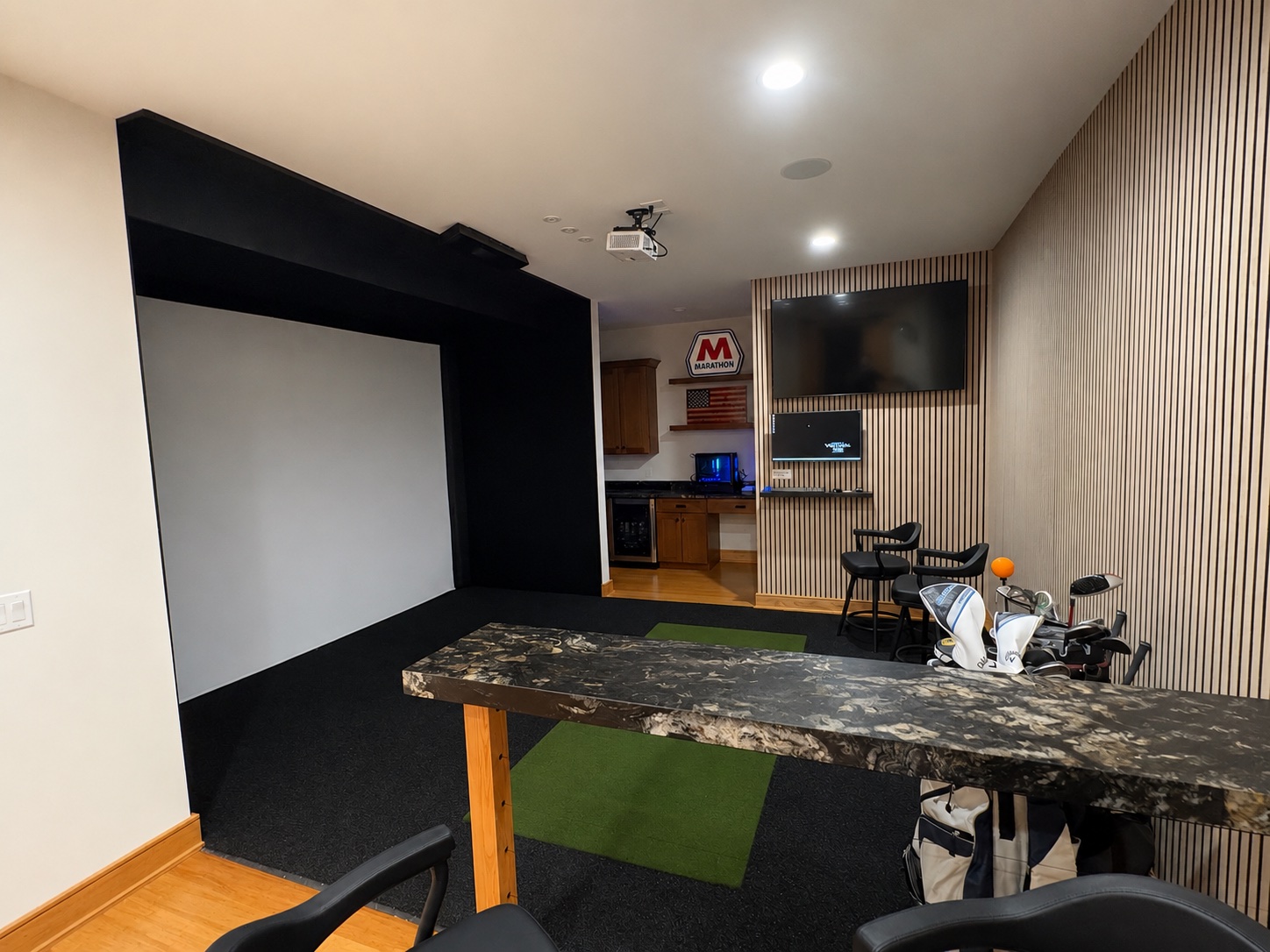 Golfers Paradise basement — golf simulator with projection screen, hitting mat, and granite bar top by Luxe Built Louisville KY